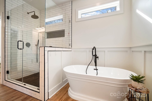 bathroom featuring plus walk in shower and wood-type flooring