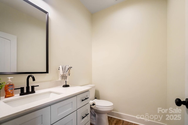 bathroom with vanity, toilet, and wood-type flooring