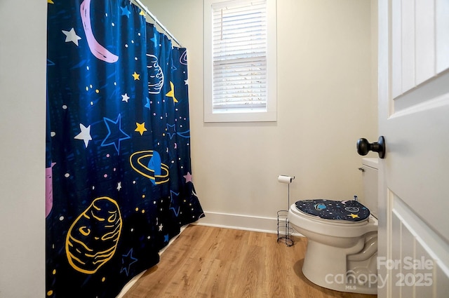 bathroom featuring a shower with shower curtain, hardwood / wood-style floors, and toilet