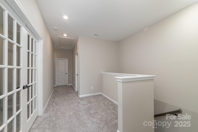 corridor featuring light colored carpet and french doors