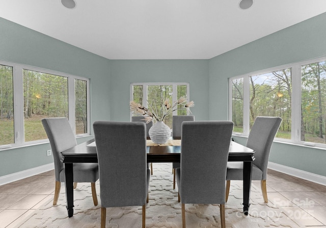 dining space with baseboards and tile patterned flooring