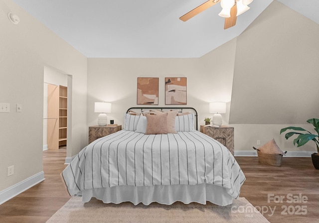 bedroom featuring baseboards, vaulted ceiling, a ceiling fan, and wood finished floors