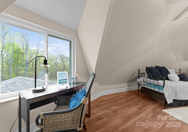 home office featuring baseboards, a ceiling fan, vaulted ceiling, and wood finished floors