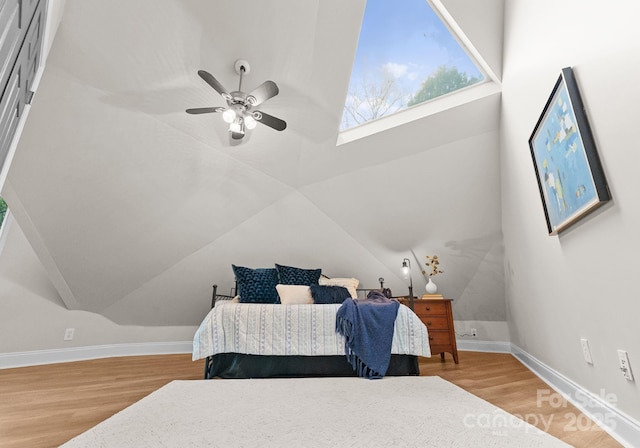 bedroom with baseboards, vaulted ceiling, and wood finished floors