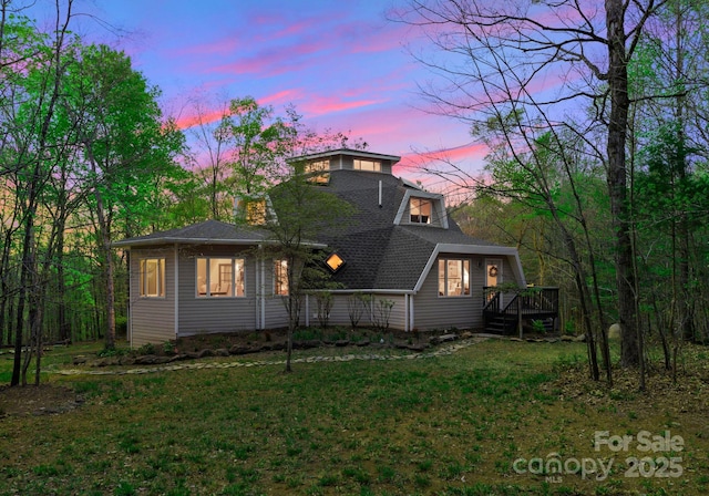 view of front of property featuring a chimney, a shingled roof, and a front lawn