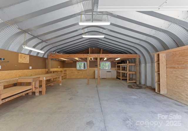 interior space featuring concrete floors and vaulted ceiling