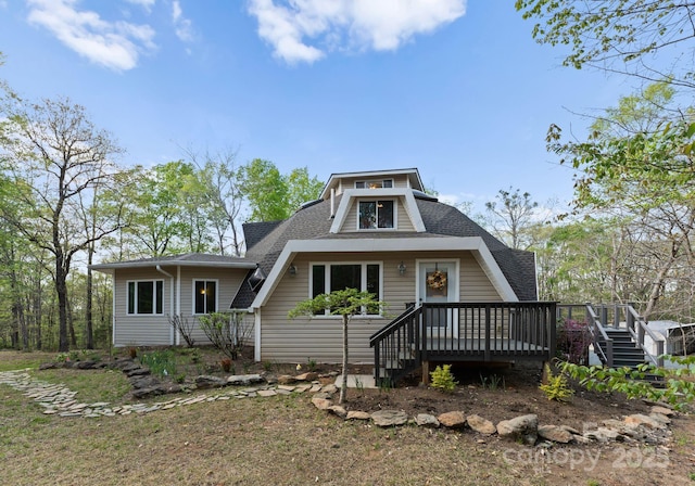 view of front of house featuring a shingled roof and a deck