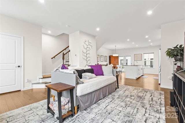 living room featuring sink and light hardwood / wood-style flooring