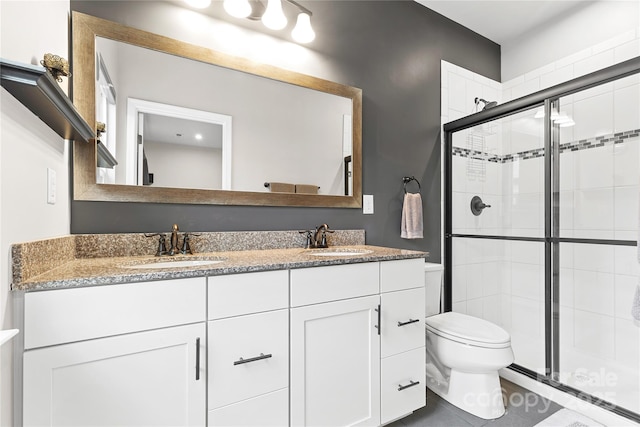 bathroom with vanity, tile patterned flooring, a shower with shower door, and toilet