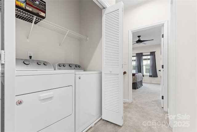 laundry room featuring ceiling fan, light colored carpet, and washer and dryer