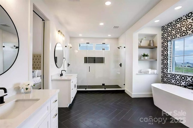 bathroom featuring built in shelves, vanity, and separate shower and tub