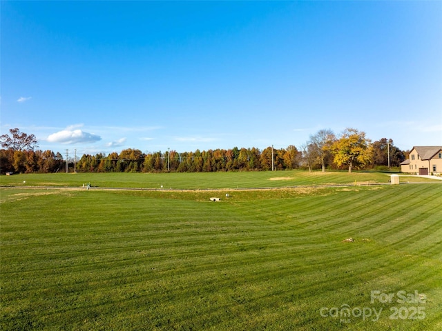 view of property's community featuring a rural view and a yard