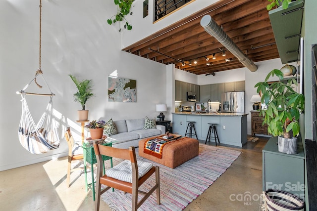 living room with a high ceiling and concrete flooring