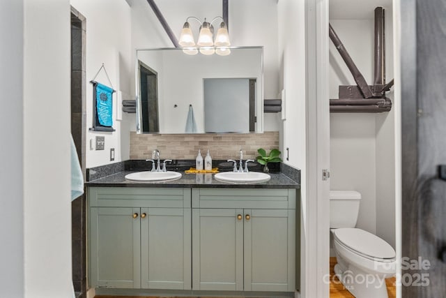 bathroom with toilet, vanity, and backsplash