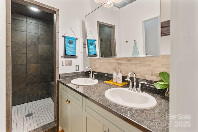 bathroom with vanity, backsplash, and tiled shower