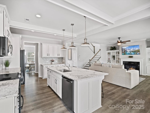 kitchen featuring appliances with stainless steel finishes, sink, a center island with sink, and white cabinets