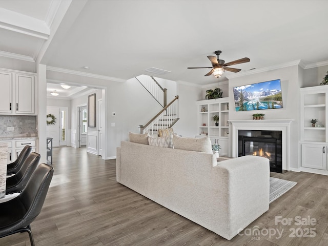 living room with ornamental molding, hardwood / wood-style floors, and ceiling fan