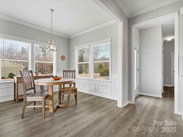 dining space with crown molding, plenty of natural light, and wood-type flooring