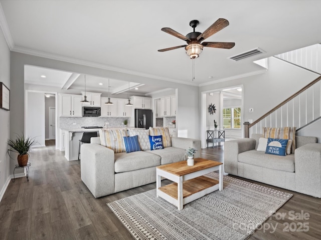 living room featuring crown molding, dark hardwood / wood-style flooring, and beamed ceiling