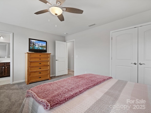 bedroom featuring ensuite bath, light carpet, ceiling fan, and a closet