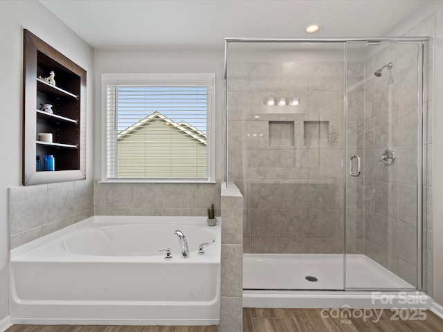 bathroom featuring wood-type flooring and separate shower and tub