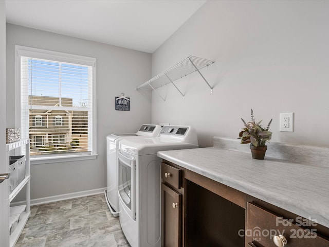 clothes washing area with cabinets, washing machine and dryer, and plenty of natural light