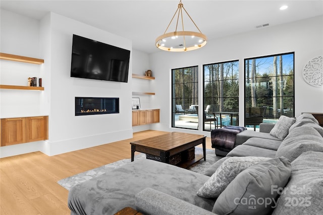 living room featuring light hardwood / wood-style flooring and an inviting chandelier