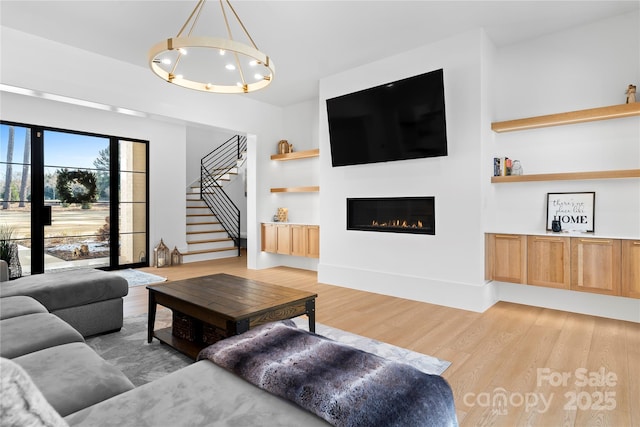 living room with a chandelier and light hardwood / wood-style flooring