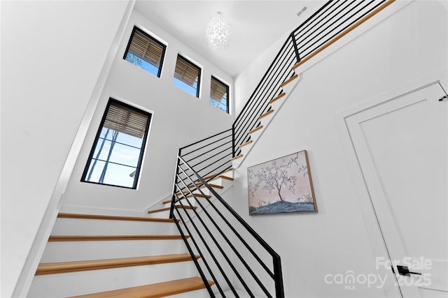 stairs with a chandelier