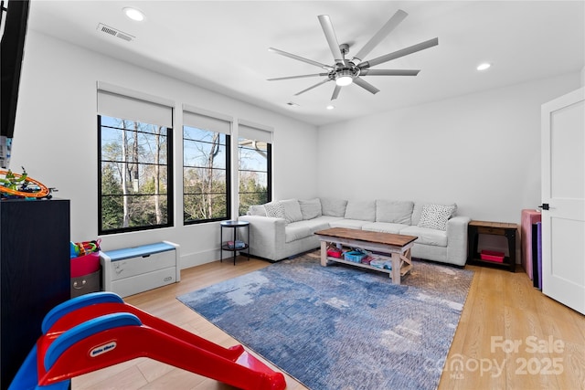 living room with ceiling fan and light hardwood / wood-style flooring