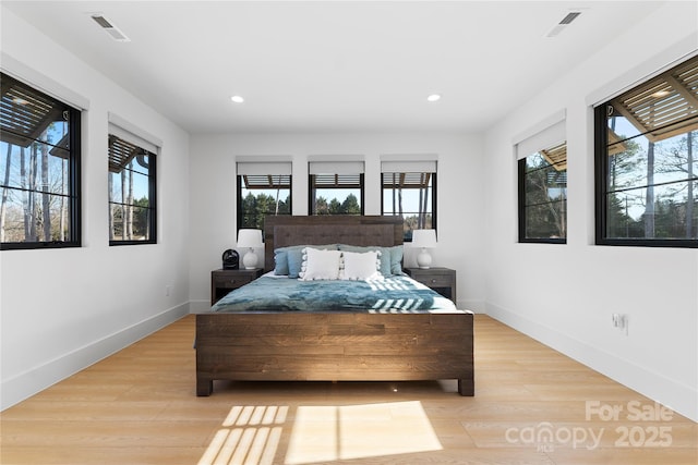 bedroom with light wood-type flooring and multiple windows