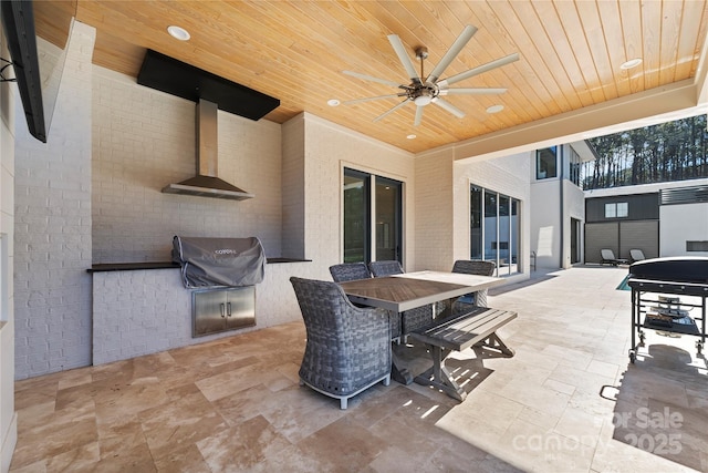 view of patio with ceiling fan, area for grilling, and exterior kitchen