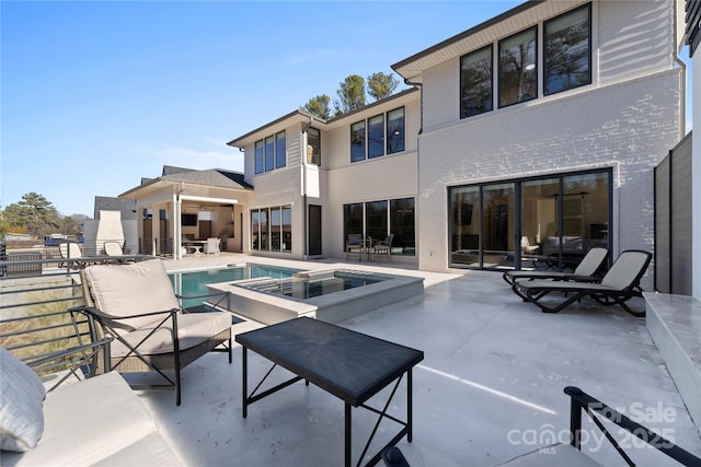 view of pool featuring an in ground hot tub and a patio