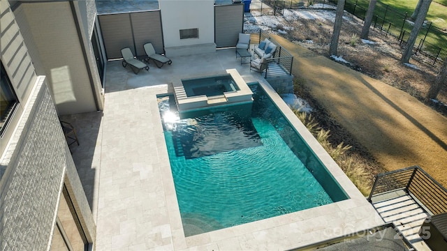 view of swimming pool featuring an in ground hot tub, a fire pit, and a patio