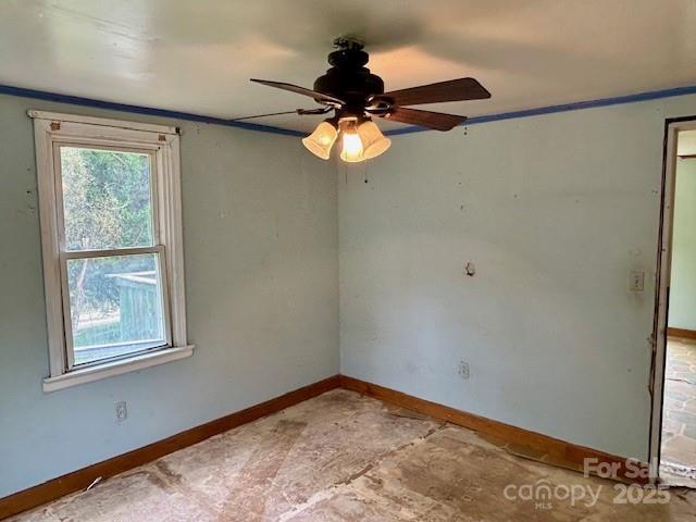 spare room featuring ceiling fan and ornamental molding