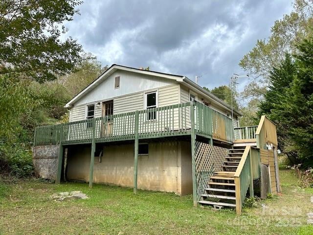 rear view of house featuring a yard and a wooden deck