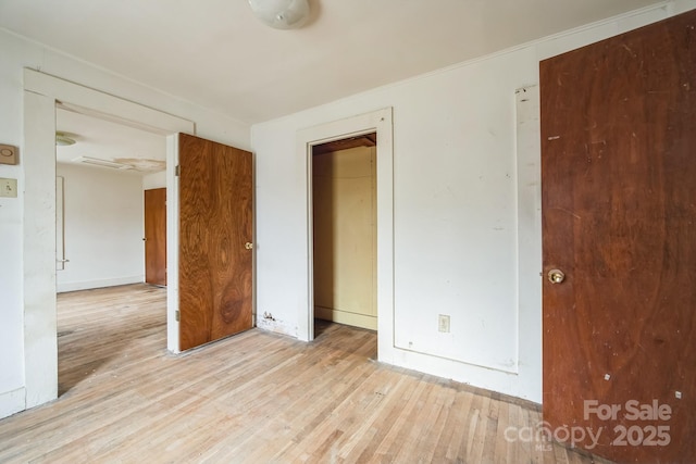 unfurnished bedroom with light wood-type flooring and a closet