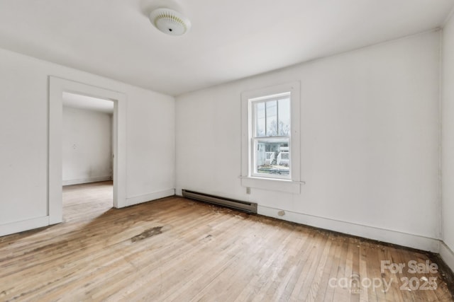 unfurnished room with light wood-type flooring and a baseboard radiator