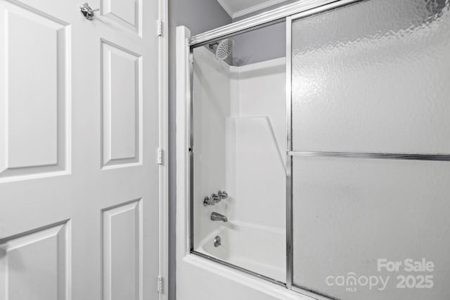 bathroom with enclosed tub / shower combo and crown molding