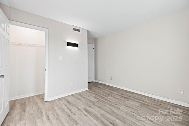 unfurnished bedroom featuring light hardwood / wood-style flooring and a closet