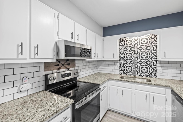 kitchen featuring tasteful backsplash, appliances with stainless steel finishes, and white cabinets