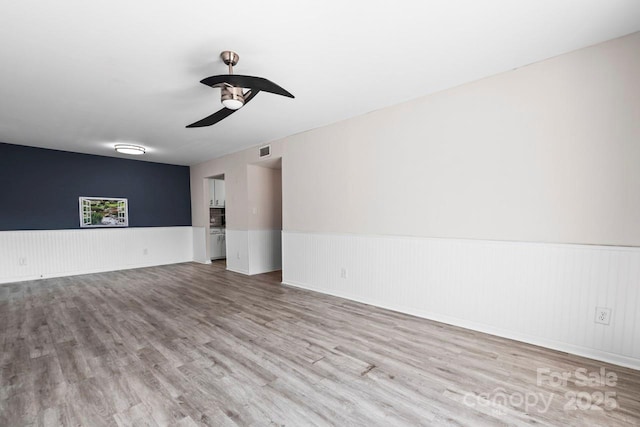 empty room featuring ceiling fan and light hardwood / wood-style flooring