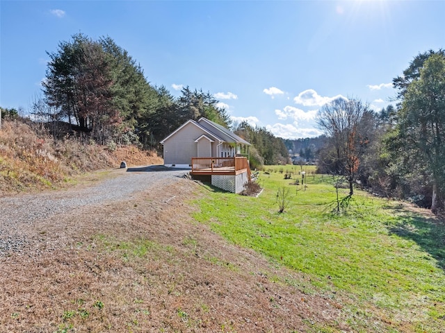 view of front of house with a front yard, a rural view, and a wooden deck