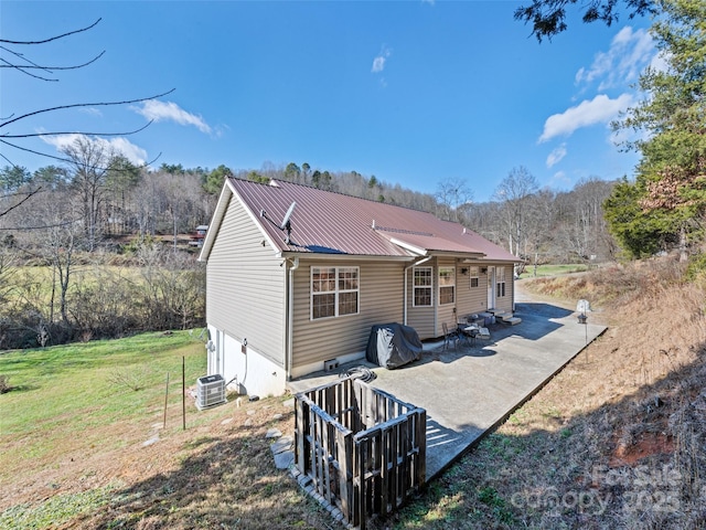 back of property with central air condition unit, a yard, and a patio