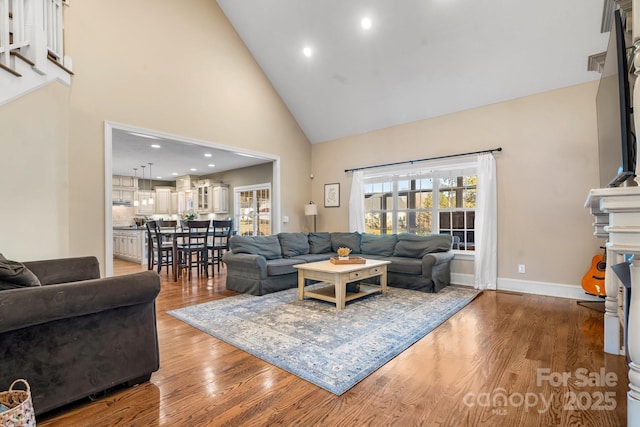 living room with high vaulted ceiling and hardwood / wood-style floors