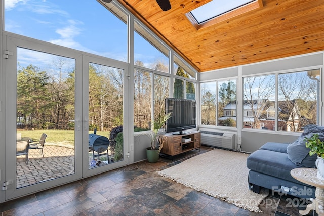 sunroom featuring an AC wall unit, ceiling fan, lofted ceiling with skylight, and wooden ceiling