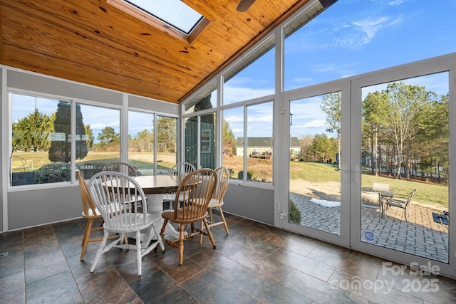 sunroom / solarium featuring lofted ceiling with skylight and wood ceiling