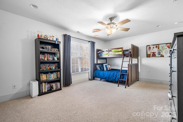 bedroom featuring a textured ceiling, ceiling fan, and light colored carpet