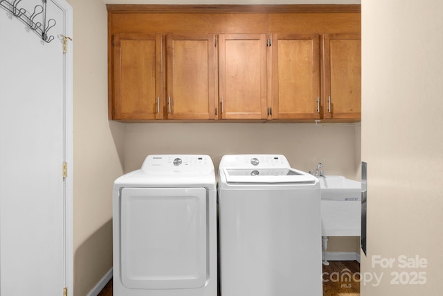 laundry room with washing machine and clothes dryer and cabinets