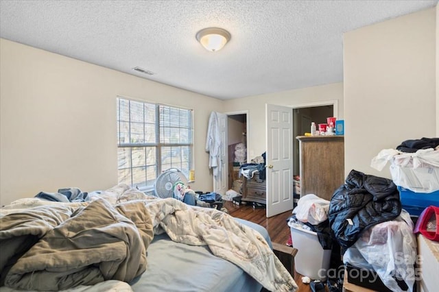 bedroom with a textured ceiling and dark wood-type flooring